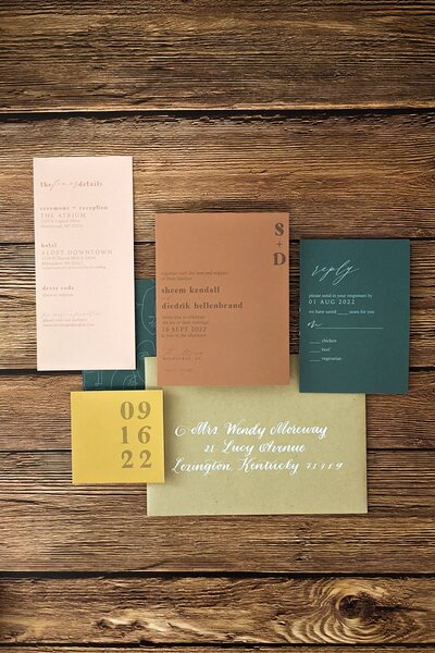 save the date and wedding invitations laid out on a wooden table