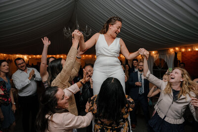 Guests holding up a bride at the reception