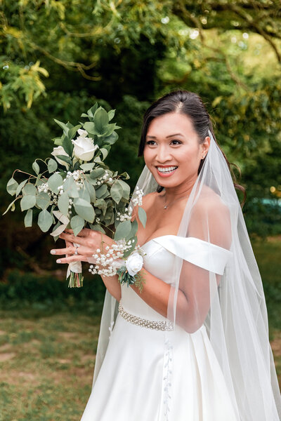 Bride holding a bouquet of roses and eucalyptus