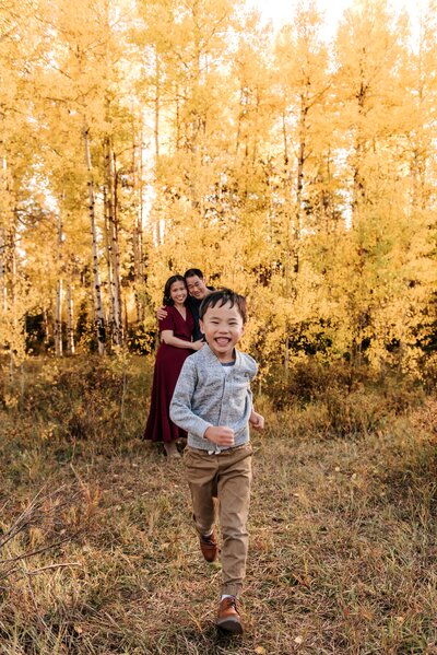 Boy running and playing with Aspen trees surrounding