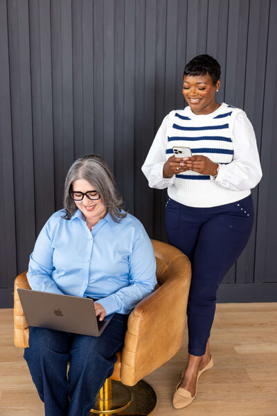 Two WLS Interests employees smiling while working at a computer in the Houston office, showcasing the supportive and positive work environment within the company’s property management team.
