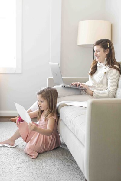 woman on coach with computer with daughter