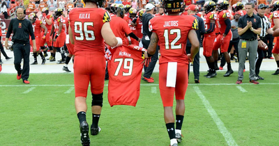 Football players carrying the jersey of a teammate