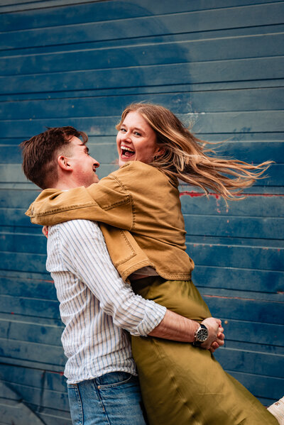 Couple standing looking at each other lovingly. Standing in front of a graffiti wall.