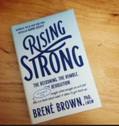 Rising Strong book sitting on a wood table