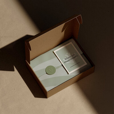 Mailer box featuring a custom brand pattern and a thank you card for Village Motherhood, showcasing elegant and thoughtful packaging design.