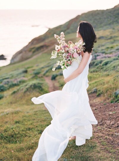 Sunset maternity photos in San Francisco in a scenic outdoor location, with the expectant mother in a flowing dress.