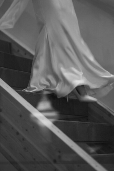 an out of focus image of a bride in a tight lace dress and full coverage veil turning to see her groom over her shoulder
