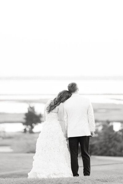 Bride and Groom overlooking the ocean during their portrait session at their wedding reception at Hyannisport Club in Cape Cod