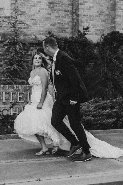 Bride and groom running together in front of church after their ceremony