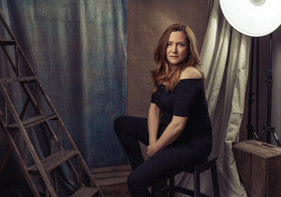 Portrait of a woman in her 40s wearing a black top and jeans posing in an editorial style by Portrait Photographer Claire Howes, Norwich.