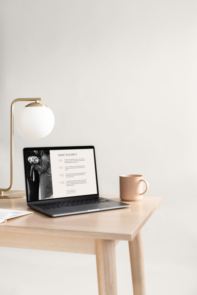 Open laptop on a table with a mug and lamp