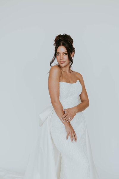 bride posing in front of flower arch