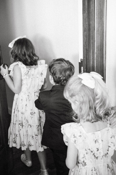 flower girls and ring bearer walk together around ceremony space kansas city wedding