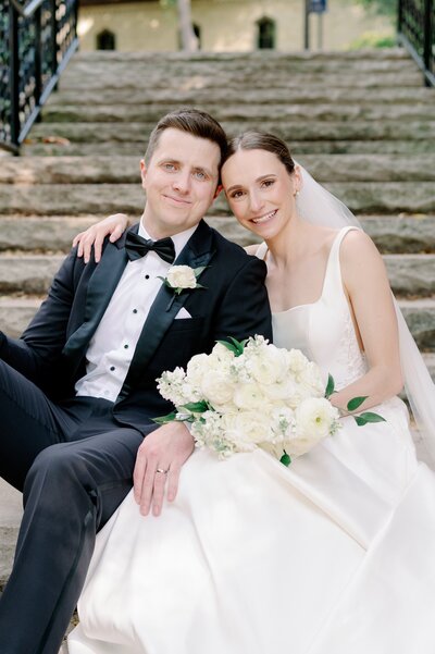 bride and groom sitting together on stone steps