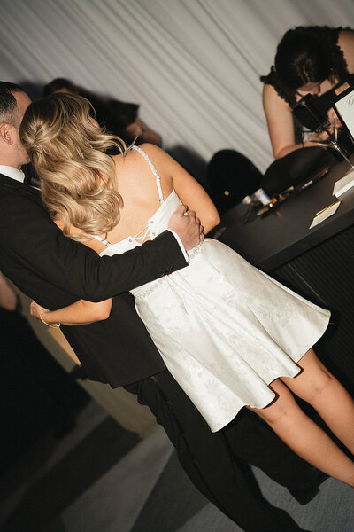 Bride and groom watch live engraver make custom wedding favors at a Scottsdale wedding