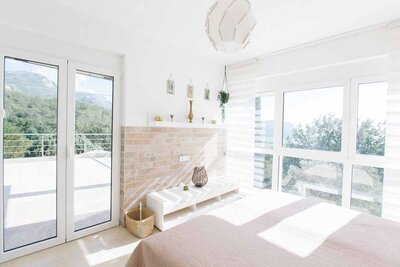 Bedroom in beige colours with big windows 