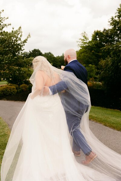 Bride and groom walking together outside.