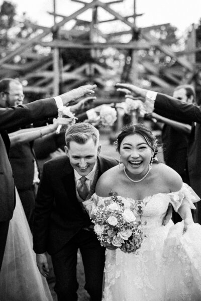 A black and white image of the bride securing her earrings