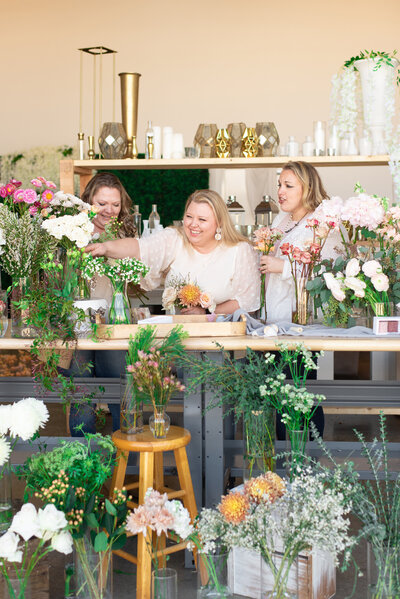 Natasha Larson selecting flowers for bouquets alongside her floral designer team
