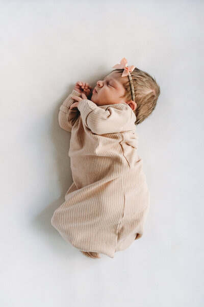 baby girl in crib wearing a bow
