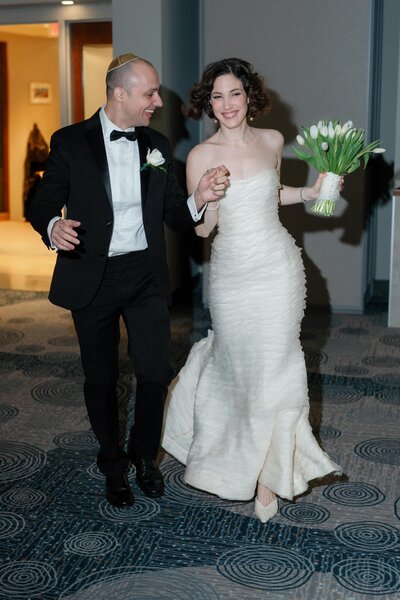 bride and groom are making their entrance to their wedding reception after getting married