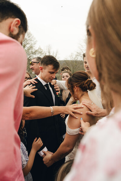 A bride and groom walking after their wedding ceremony in Austin, Texas. The bride is holding her flowers, the groom is holding her dress. 