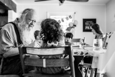 Grandparent and child sharing a quiet creative moment at home, captured by a documentary photographer in Rhinebeck.