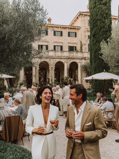 Guests connecting at curated travel experience in historic European courtyard. Tailored Oasis Travel Co.