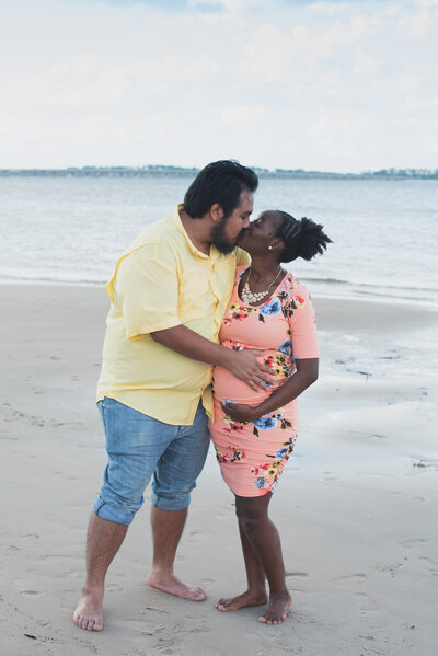 Couple kissing during their maternity session at  Boneyard Beach in Jacksonville