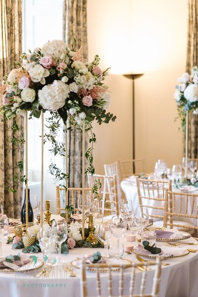 A tall gold stand of flowers on the tables at Boconnoc