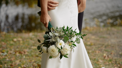 bride holding flowers while groom embraces her
