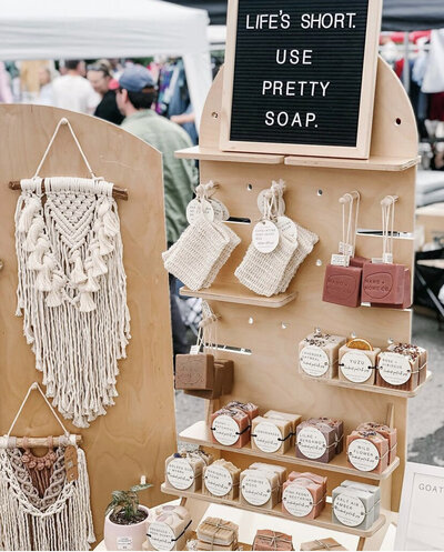 pretty soap on wooden display shelves at vendor market