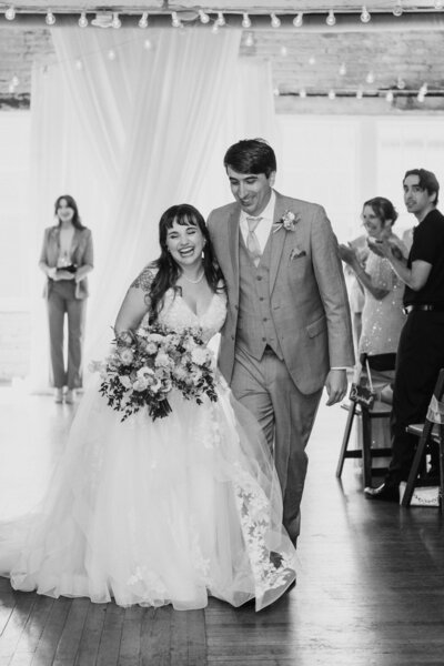 Couple walking down the aisle, smiling