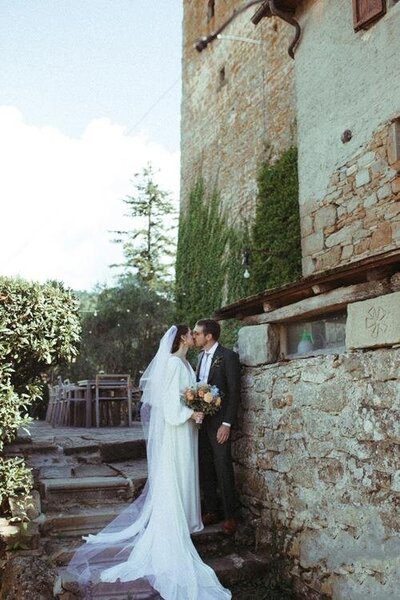 Bride and groom kissing during their wedding day in Tuscany, Italy.