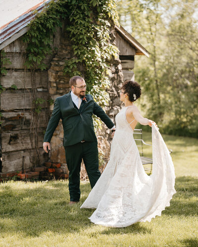 A newlywed couple holding hands and dancing together 