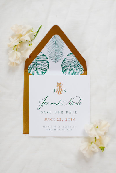 Colorful green and orange monstera wedding invitations with custom calligraphy