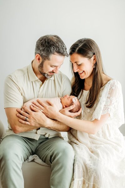 a new mother looks fondly at her sleeping newborn