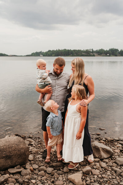 family looking at each other smiling by water