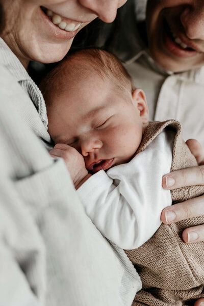 Kleine baby ligt lekker tegen mama