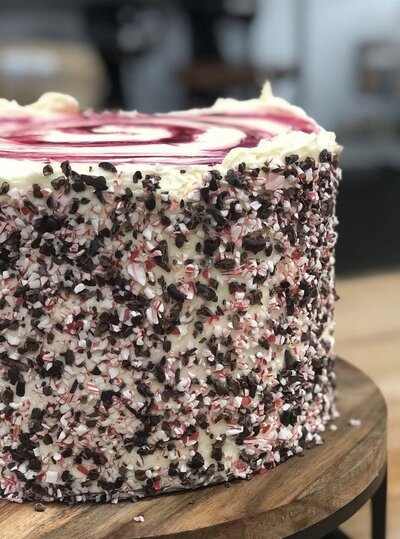 Gluten-free dark cacao peppermint crunch cake from Grain Artisan Bakery, topped with festive chocolate flakes for the winter season.