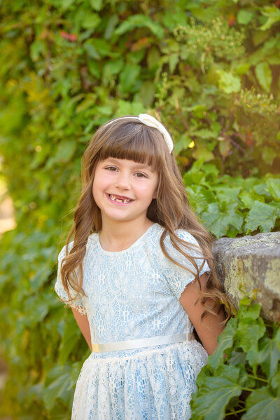 little girl missing top two teeth smiling during child photography in boise