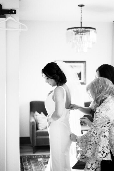 Bride putting on wedding dress