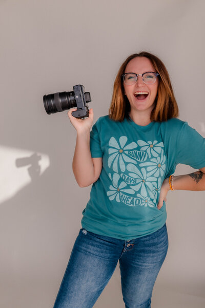 Woman smiles at the camera with Nikon Z6II Camera in hand.