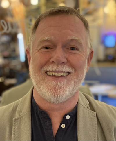 Phil Hickey, a Trust Partner with Learners’ Trust since 2016, is pictured in a thoughtful pose reflecting his extensive leadership journey. With over 20 years of experience, Phil has transformed schools, taking five from requiring improvement to OFSTED good ratings. His career highlights include leading a school from serious weaknesses to top improvement lists and creating a successful federation that eventually formed Learners’ Trust MAT. An accomplished Headteacher, mentor, and author of ‘Going Further – One School’s Journey Through Curriculum Development,’ Phil is also a curriculum consultant and passionate advocate for leadership development. His role as a psychotherapeutic counselor adds a layer of compassion and empathy to his work, underpinned by his strong inter-personal skills and dedication to nurturing future leaders.