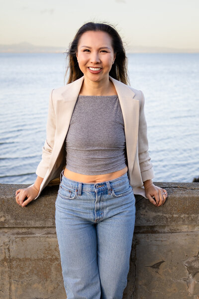 Smiling woman standing confidently by the water during a branding session with a Bay Area family photographer.