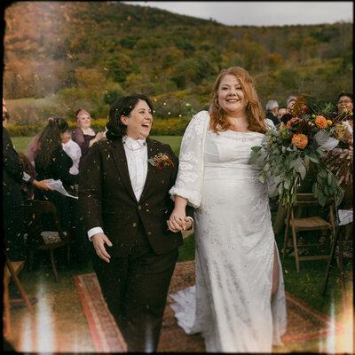lesbian brides walking down the aisle captured by new york wedding photographer