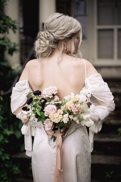 Bride styled with a romantic low bun and soft, loose curls — dreamy, natural bridal hair by Klover Beauty in Maryland.