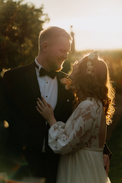 Groom giving bride a piggyback ride at outdoor reception