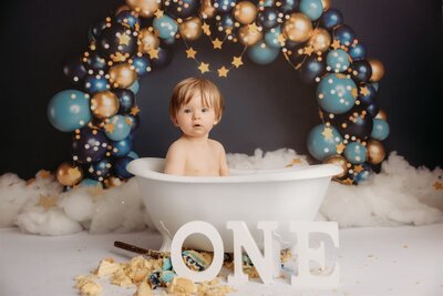 Torben sitting in a bath after his starry night themed cakesmash photoshoot